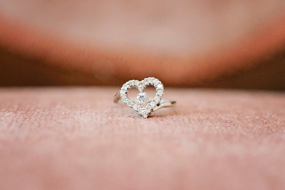 A close-up detail shot of a diamond ring in the shape of a heart.