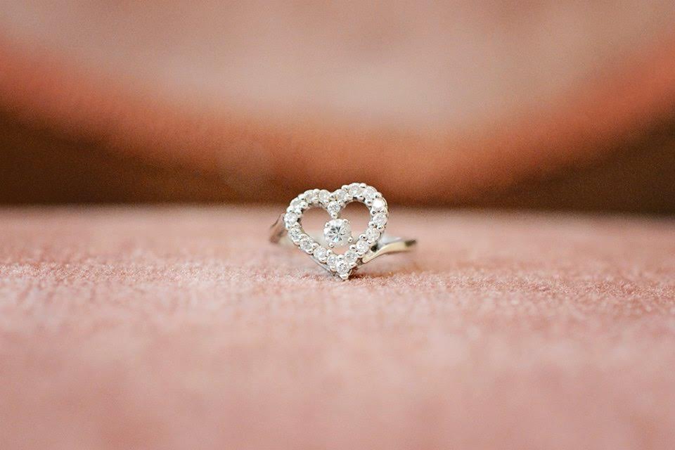 A close-up detail shot of a diamond ring in the shape of a heart.