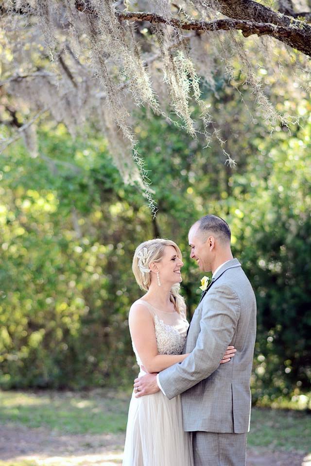 A bride and groom embrace under the Spanish moss of Charleston's sleepy oak trees.