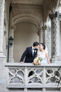 Traditional bride and groom prepare to kiss on the colonnade of the Biltmore Estate.